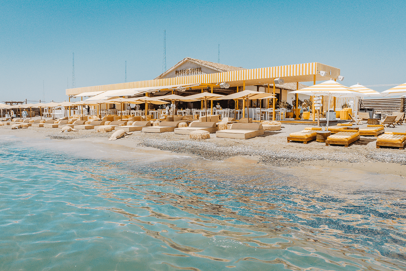 Beachfront dining table set against the Mediterranean Sea